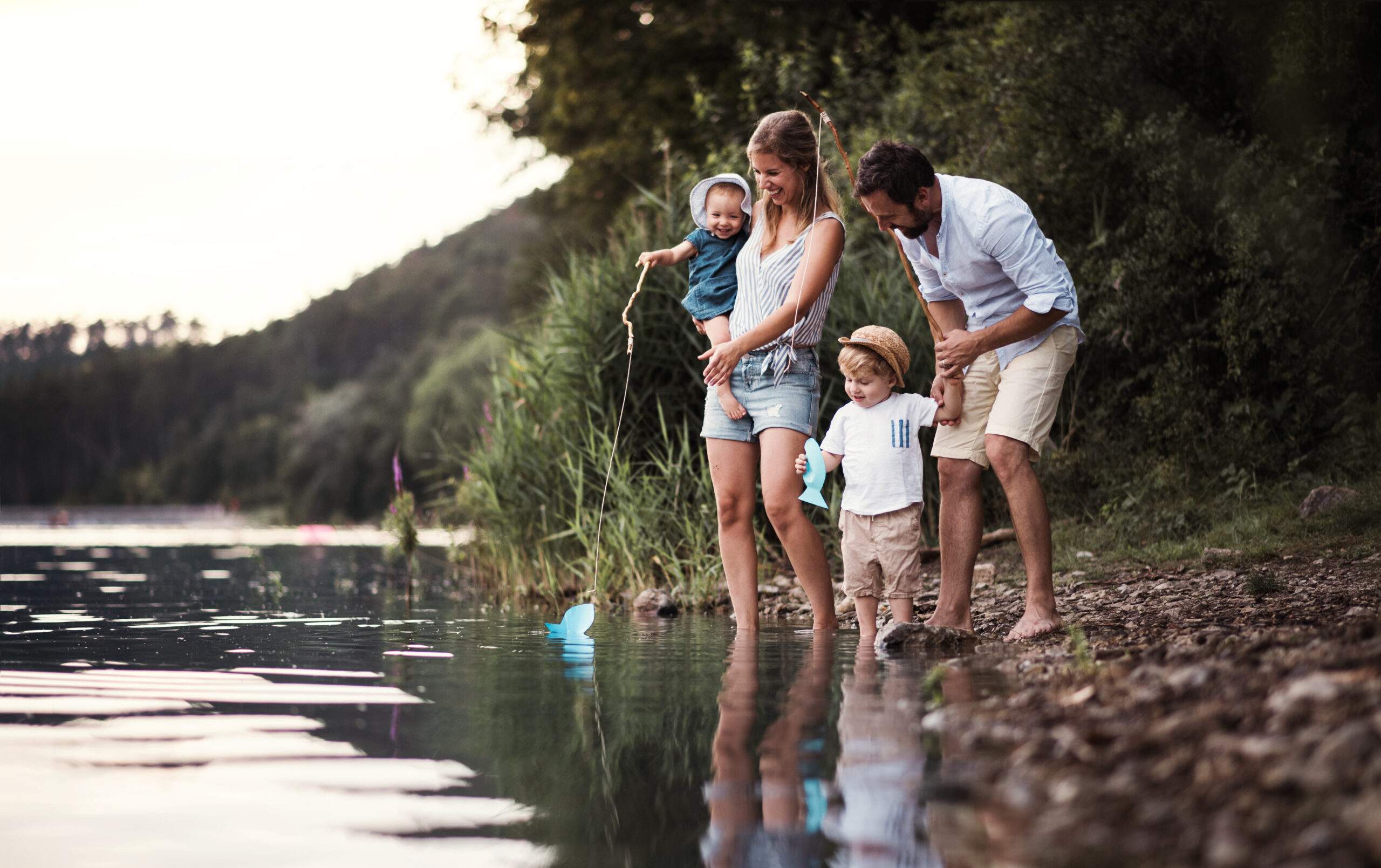 independent mortgage broker A young family with two toddler children outdoors by the river in summer.